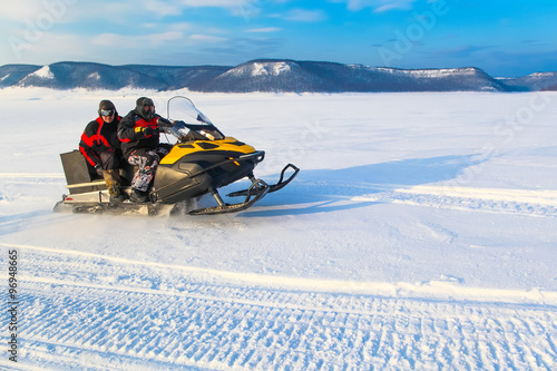 Bild auf Leinwand people driving  snowmobile in winter mountain