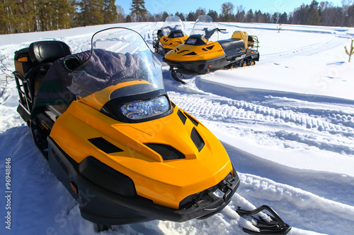 people driving snowmobile in winter mountain 