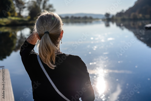 Eine Frau sieht auf einen See hinaus.  photo