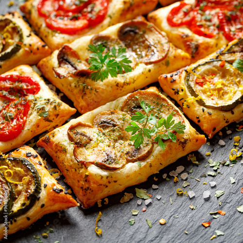 Small vegetable tarts with puff pastry, tomato, mushrooms and zucchini