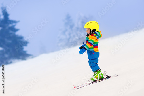 Little child skiing in the mountains in winter