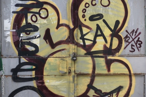 Urban Iron Closed Gate With Padlock And Street Graffiti