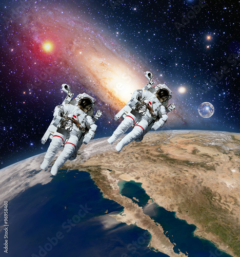 Fototapeta Naklejka Na Ścianę i Meble -  Two astronauts spaceman planet earth outer space moon milky way galaxy. Elements of this image furnished by NASA.