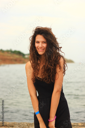 Fototapeta Naklejka Na Ścianę i Meble -  Beautiful slim brunette girl model posing in fashion dress by the sea, outdoor portrait
