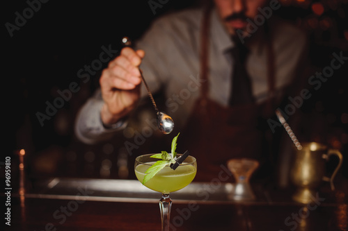 Foto Close-up of bartender making green cocktail