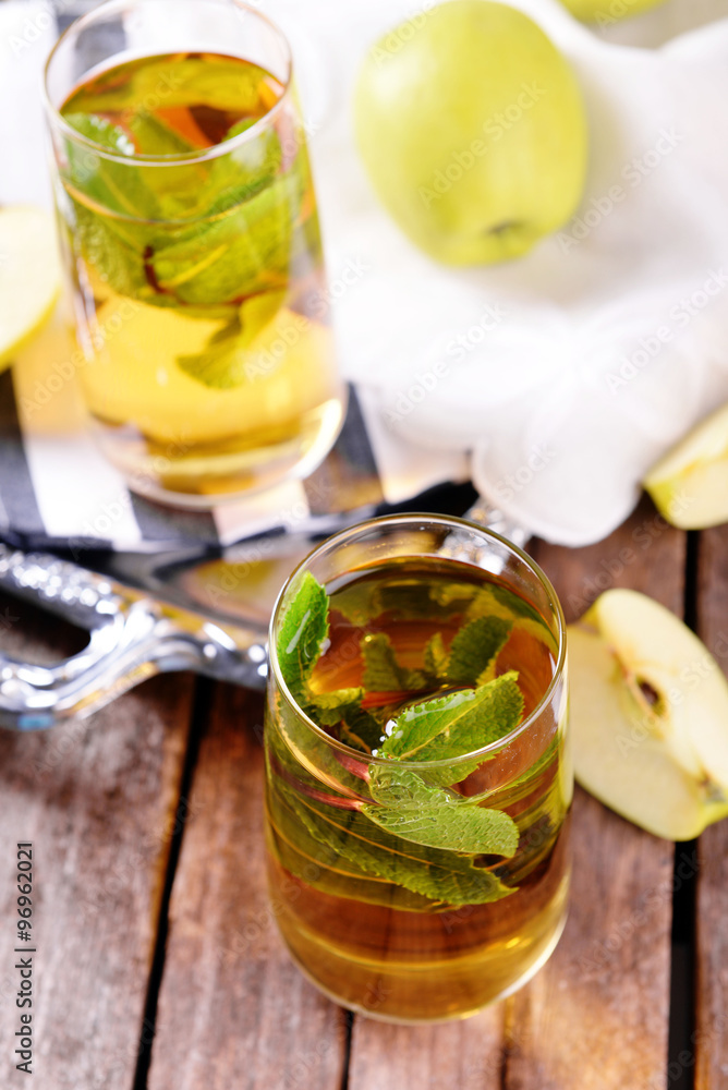 Glasses of apple juice with fruits and fresh mint on table close up Glasses of apple juice with fruits and fresh mint on table close up