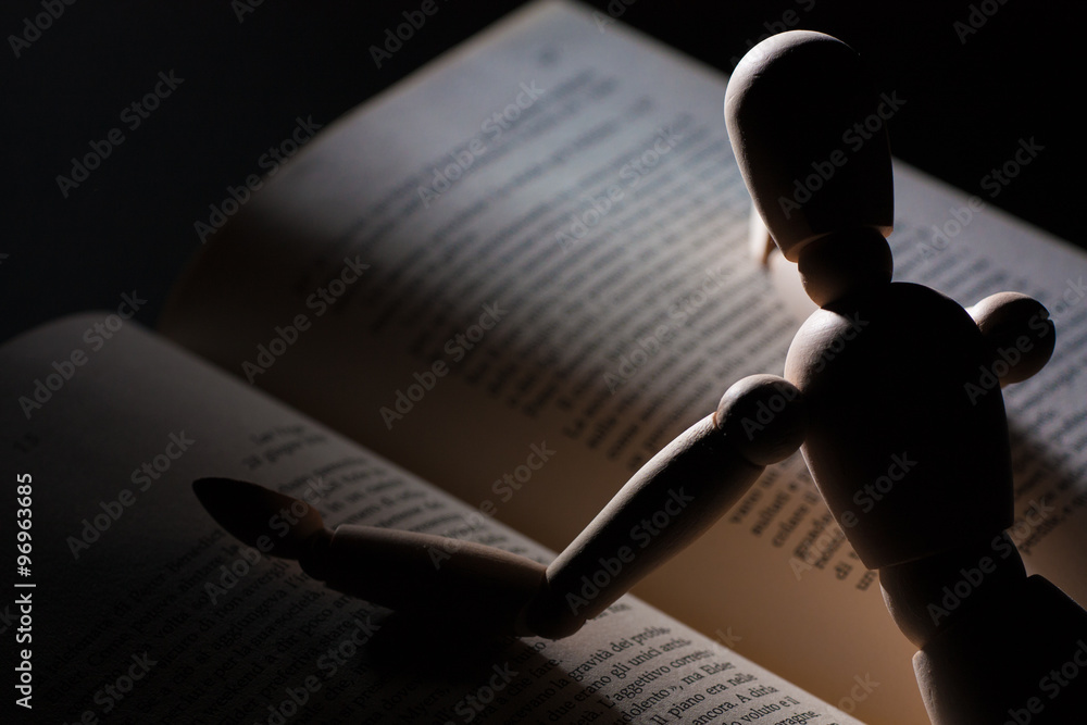 Foto Wooden puppet reading a book