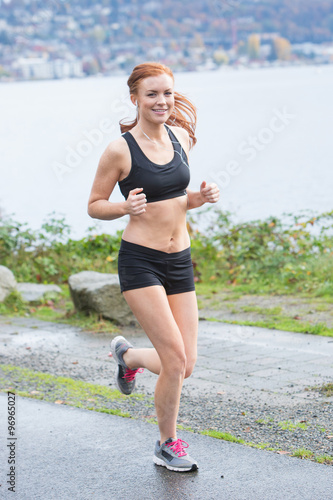 Healthy woman running near water outside