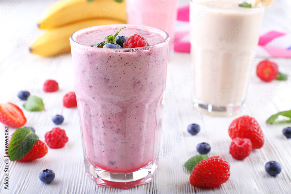 Milkshakes with berries on light wooden background Milkshakes with berries on light wooden background