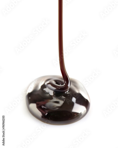 Melted black chocolate pouring, isolated on white