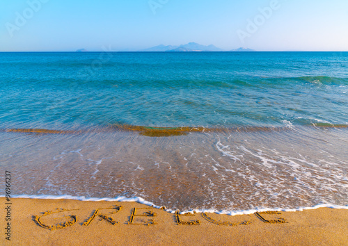 the name of GREECE written on the sand of Kardamaina beach at Kos island in Greece