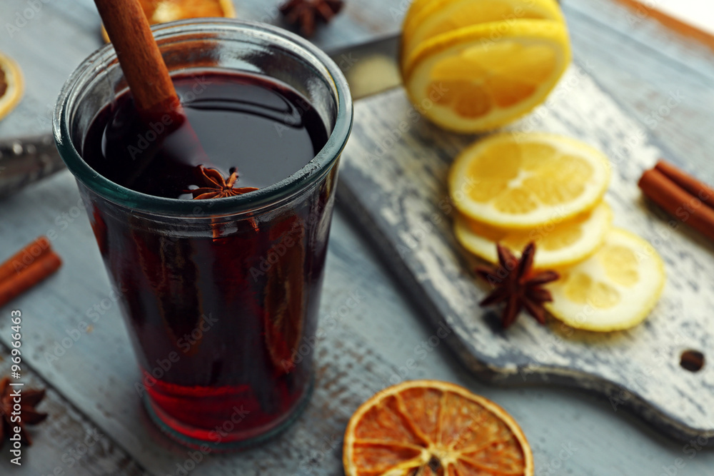 Tasty mulled wine and spices, on blue wooden background, close-up Tasty mulled wine and spices, on blue wooden background, close-up