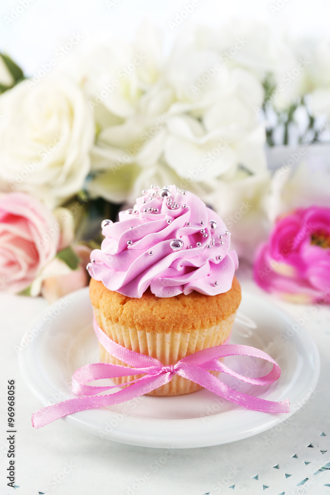Tasty cupcake on plate, on light background Tasty cupcake on plate, on light background