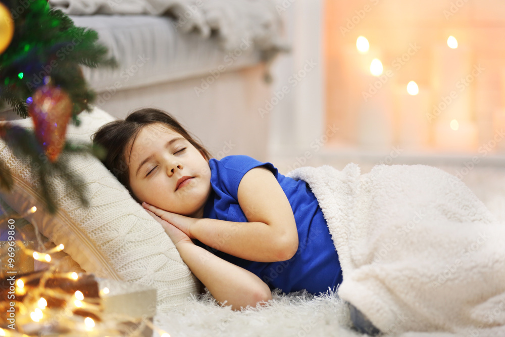 Pretty little girl sleeping on cozy sofa in Christmas decorated room Pretty little girl sleeping on cozy sofa in Christmas decorated room