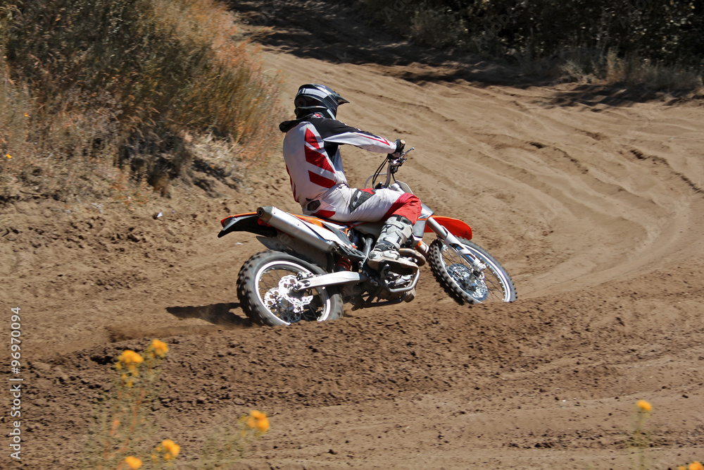 MX rider on a motorcycle rides cornering along the sandy furrow motocross track MX rider on a motorcycle rides cornering along the sandy furrow motocross track