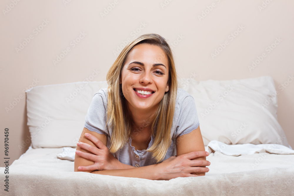 Happy woman lying on bed Happy woman lying on bed