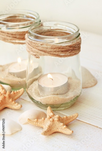 Beachy handcrafted candle lantern with sea sand for beach lovers. Jar with sand, seashells, tealight. Beige light soft tones.