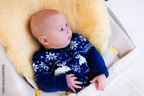 Bilde på lerret Little baby in nordic sweater on sheepskin muff