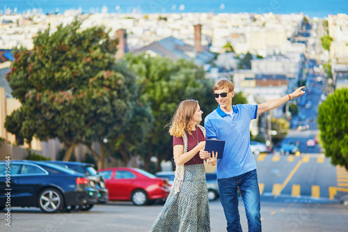 Photography Romantic couple of tourists using tablet in San Francisco, California, USA