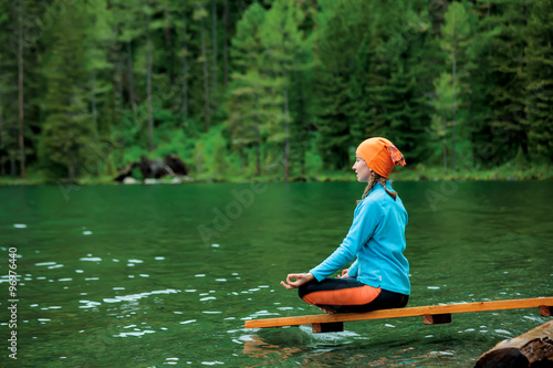 Woman is doing yoga excercises in Altai mountains