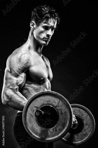 Closeup portrait of a muscular man workout with barbell at gym.