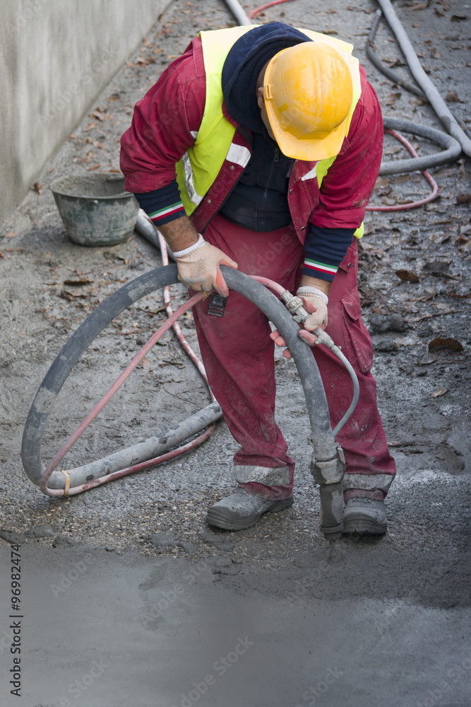 Construction worker casting concrete with pump Construction worker casting concrete with pump