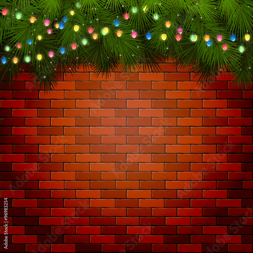 Christmas lights with spruce branches on a brick wall