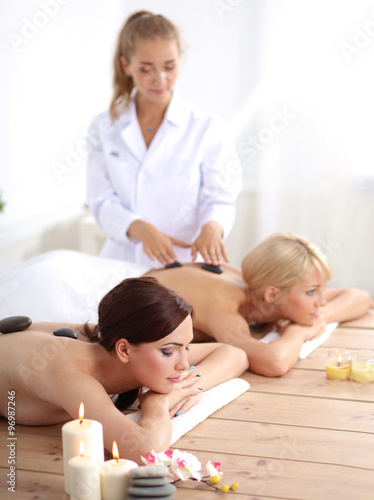 Two young beautiful women relaxing and enjoying at the spa center