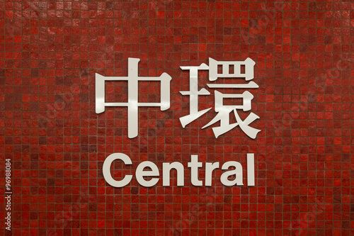 Sign of Central MTR (subway/metro) station in Hong Kong, China, written in Chinese and English on small red tile wall, viewed from the front. photo