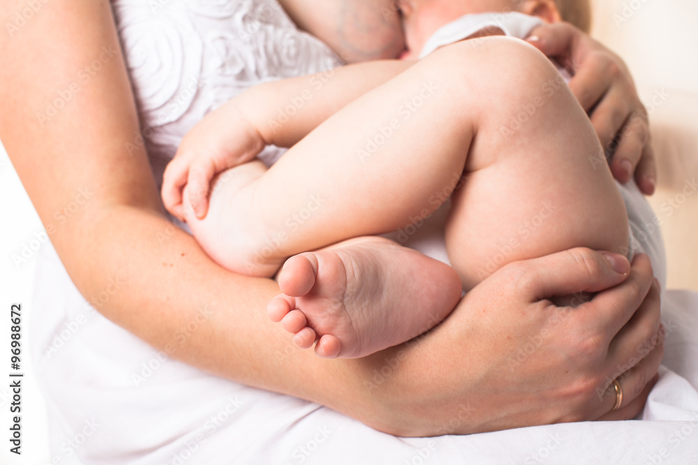 Mom feeds the baby breast, light background Mom feeds the baby breast, light background