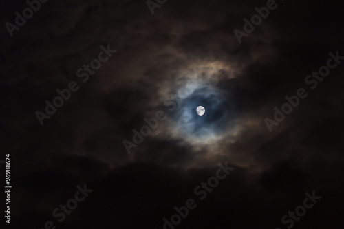 Moon on black cloudy sky, background