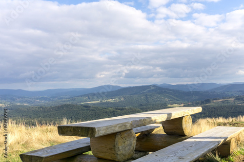 Wooden bench and mountain landscape in background, nobody. Siles