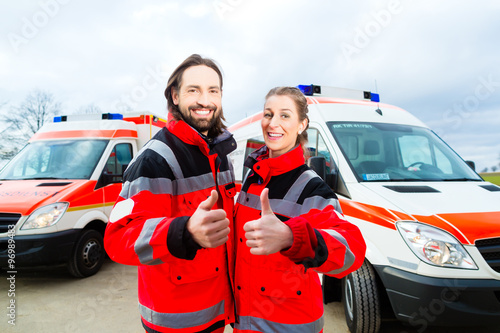 Notarzt und Sanitäter stehen vor einem Rettungswagen 