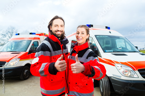 Notarzt und Sanitäter stehen vor einem Rettungswagen  photo