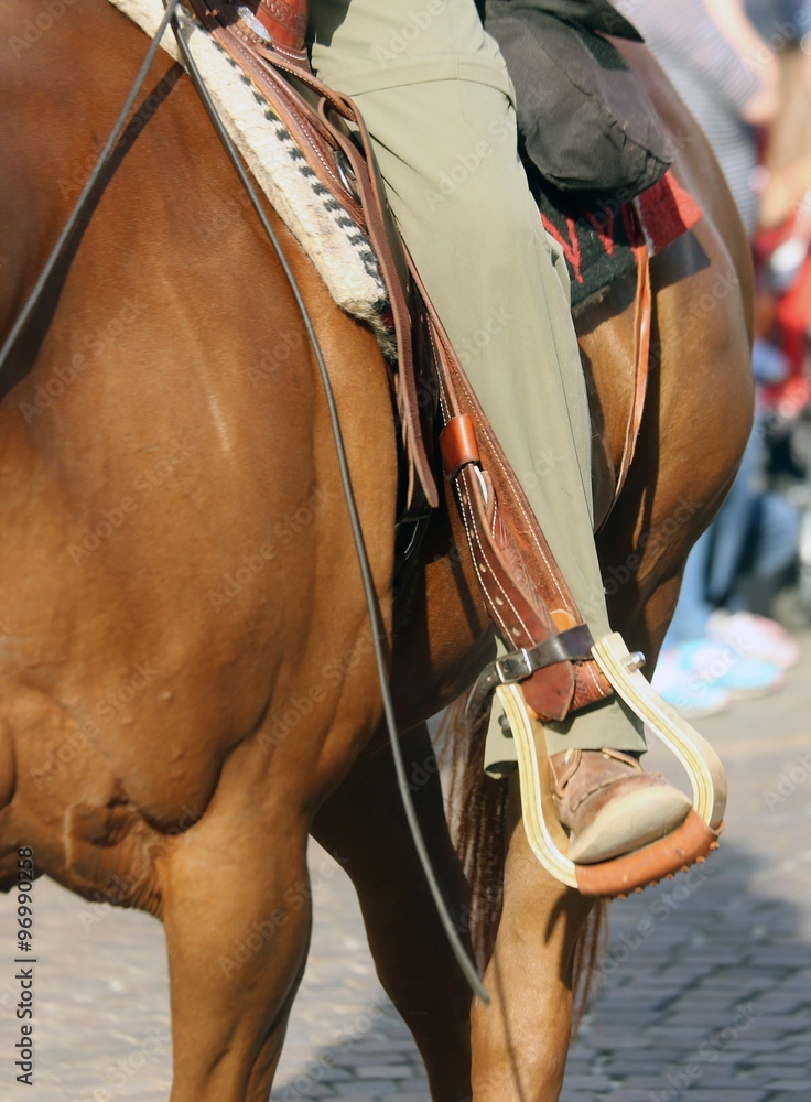 Cowboy foot in the stirrup of the horse during the ride - obrazy, fototapety, plakaty 