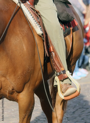 Cowboy foot in the stirrup of the horse during the ride