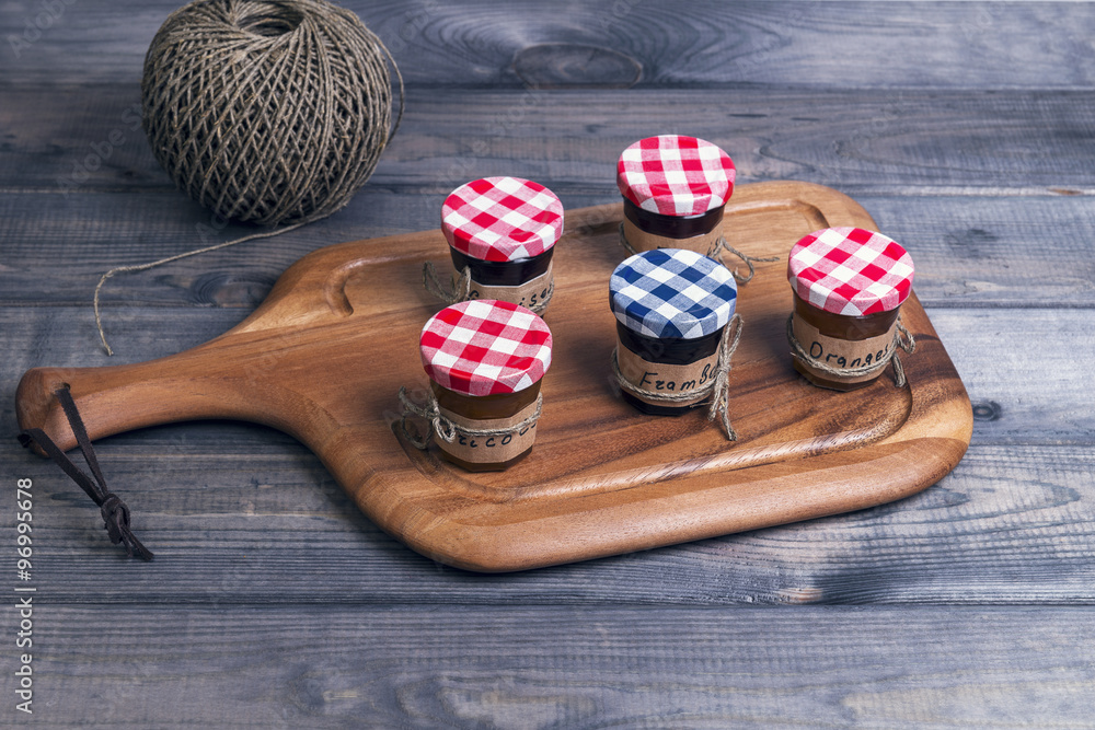 Small glass jars lids with fruit or berry jam Small glass jars lids with fruit or berry jam