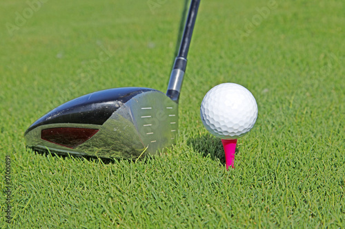 Golf club and ball in grass