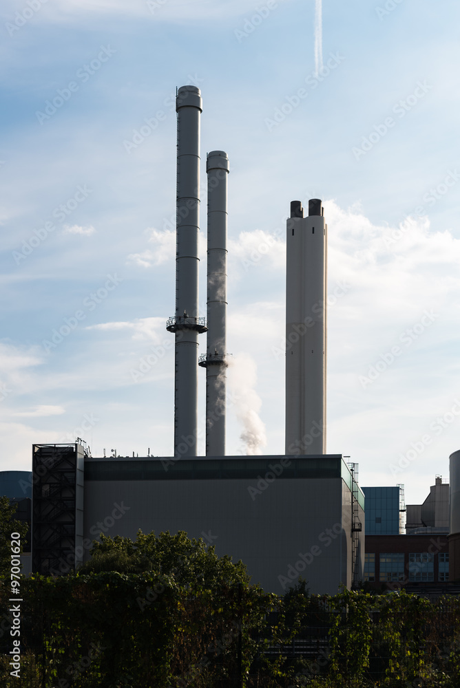 Generating plant tiefstack with smokestacks against blue sky in Hamburg. Powerhouse in industrial technology area in Germany 