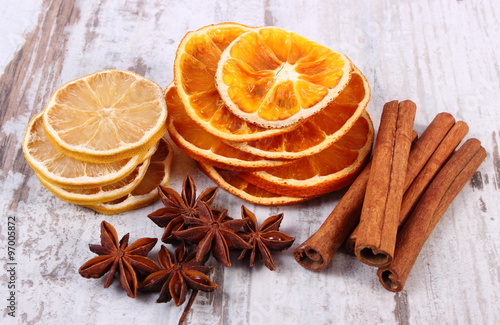 Slices of dried lemon, orange and spices on old wooden background