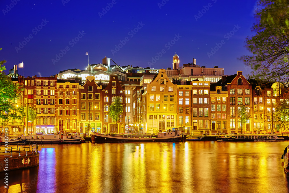 Famous Amstel river and night view of beautiful Amsterdam city.