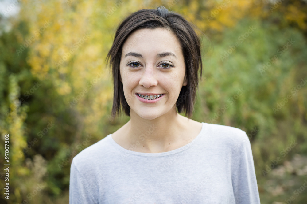 Beautiful Hispanic teen girl outdoor portrait. Cute and smiling with a mouth full of braces Beautiful Hispanic teen girl outdoor portrait. Cute and smiling with a mouth full of braces