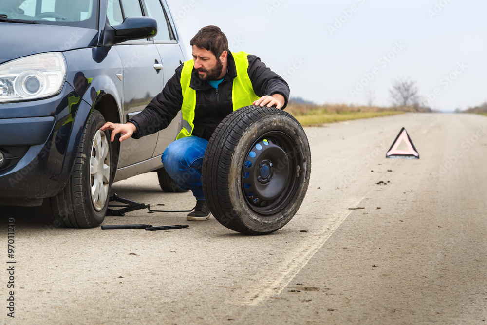 Man chaning a flat tire on his car Man chaning a flat tire on his car