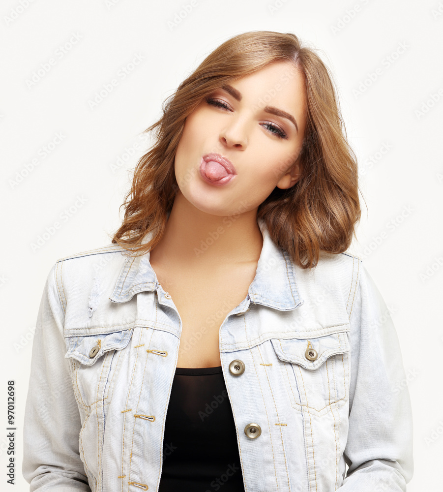 Grimacing.Beautiful young woman sticking out tongue Grimacing.Beautiful young woman sticking out tongue
