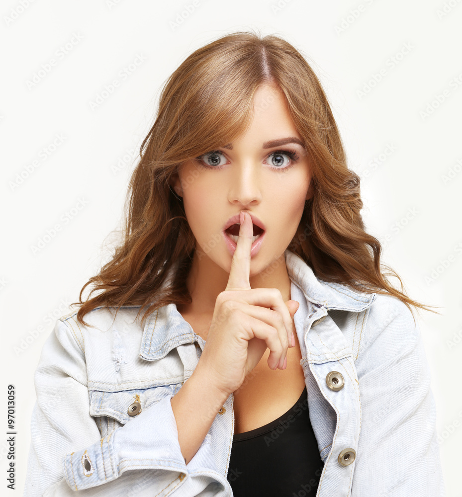 Young woman shushing,Girl holding finger on her lips. Stock Photo