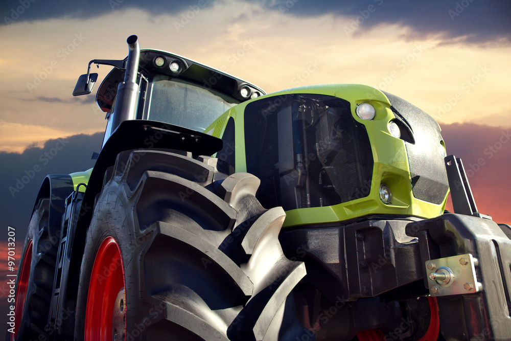 Obraz premium Farm tractor working at sunset