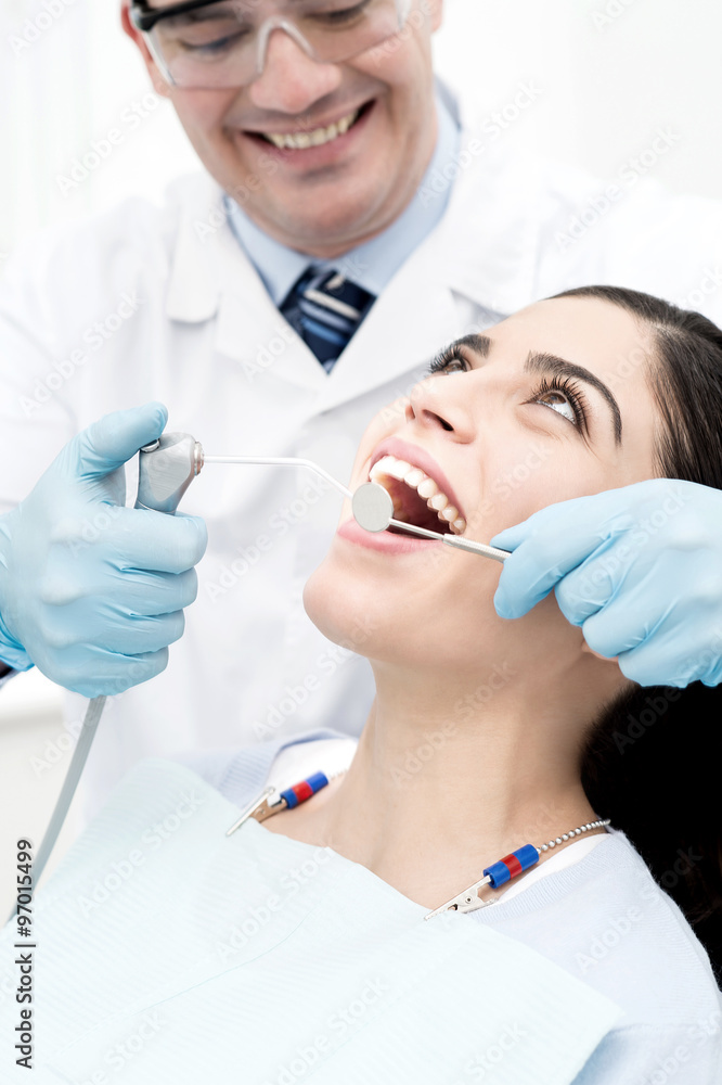 Dentist treating his patient Dentist treating his patient
