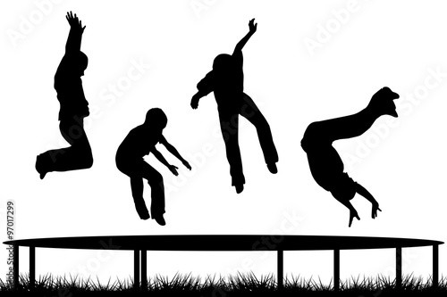 Children silhouettes jumping on garden trampoline photo
