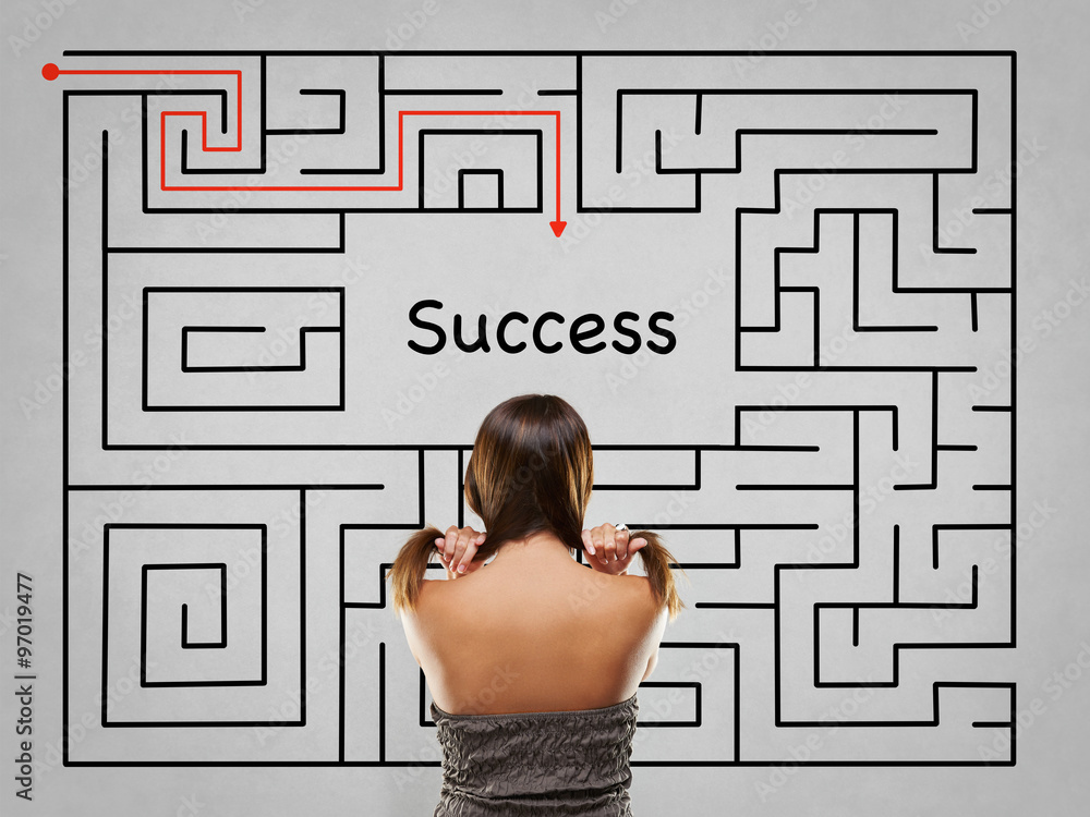 Woman pulling hair in front of labyrinth with success solution Woman pulling hair in front of labyrinth with success solution