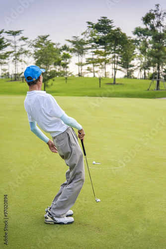 Close-up of man playing golf on green course